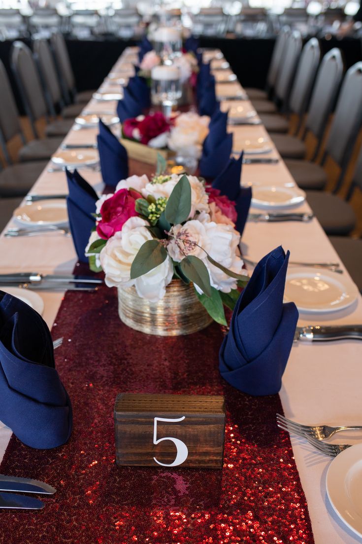 the table is set with silverware and red sequins for an elegant centerpiece