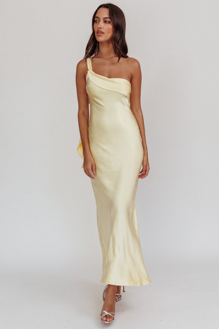 a woman wearing a yellow dress with one shoulder draped over the top and an asymmetric