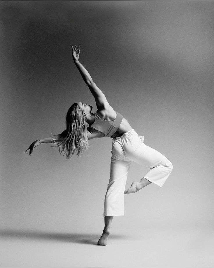 black and white photograph of a woman doing a dance move with her arms stretched out