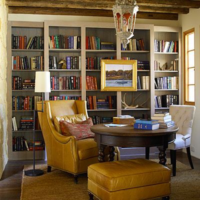 a living room filled with lots of books and furniture