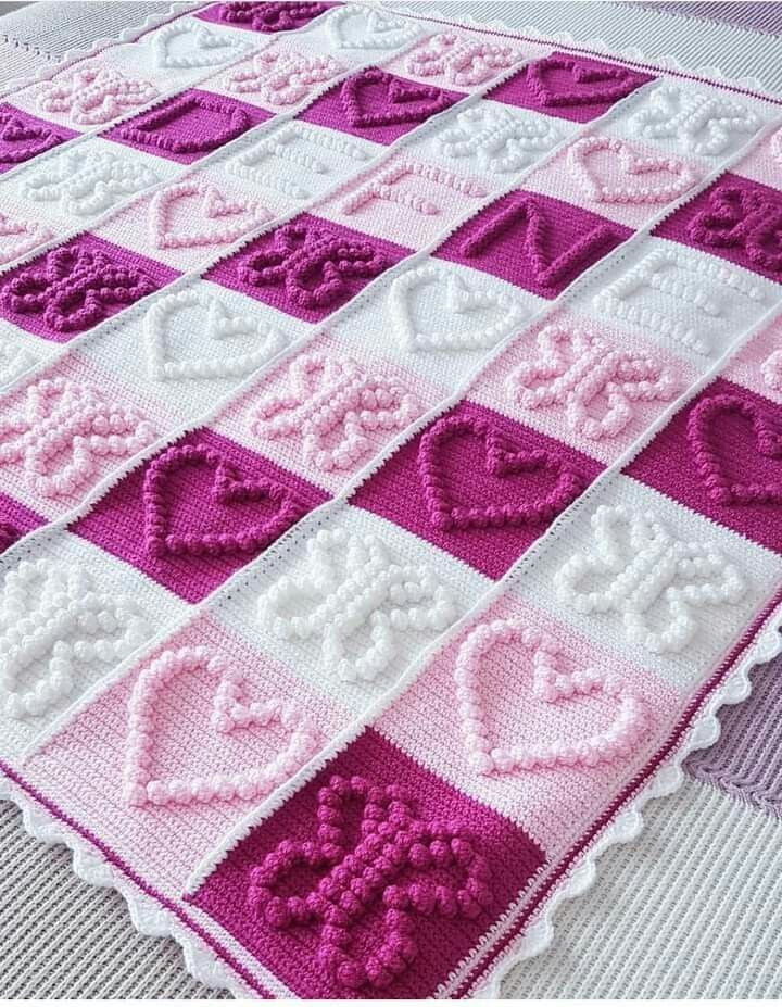 a crocheted blanket with hearts on it