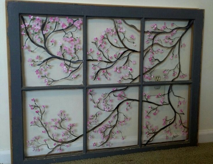 the window is decorated with pink flowers and branches on white paper, along with a gray frame