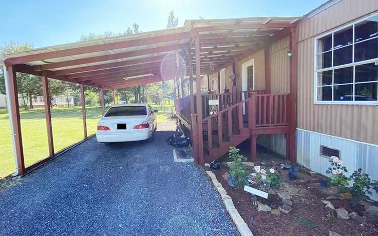 a white car parked in front of a house under a carport with a porch