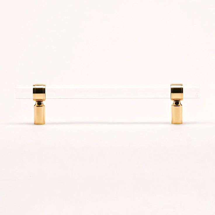 two gold - plated objects are sitting on a white surface