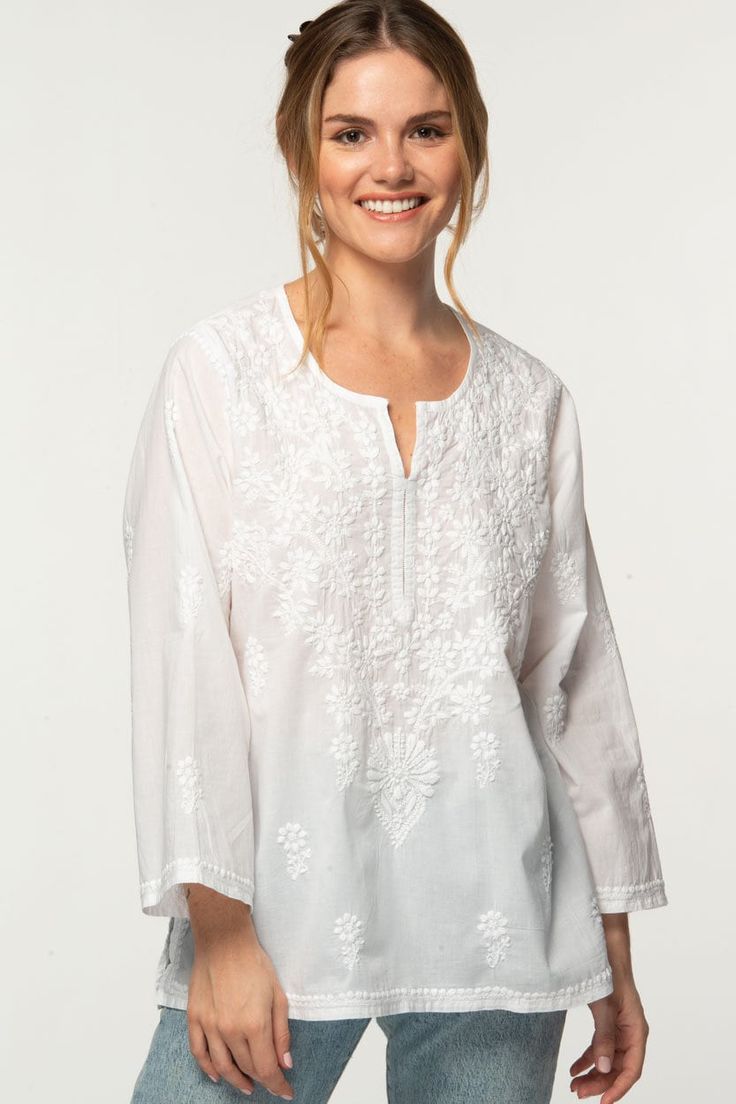 "Our Tara Tunic is hand embroidered by women artisans in Northern India in the shadow-work style known as \"Chikankari\". Chikankari is a delicate and artfully done hand embroidery technique that women in this region have been doing for generations.  Available in two sizes, S/M and L/XL, this beautiful 100% cotton tunic is designed for a comfortable and elegant fit." Luxury Chikankari Embroidered Tops For Party, Luxury Bollywood Tops With Chikankari Embroidery, Bohemian Cotton Blouse With Tonal Embroidery, Casual Embroidered Top With Chikankari, Bohemian Blouse With Woven Motifs, Traditional White Embroidered Top, Traditional White Chikankari Embroidered Top, Transitional Tops With Resham Embroidery, Cotton Embroidered Fabric With Folk Style