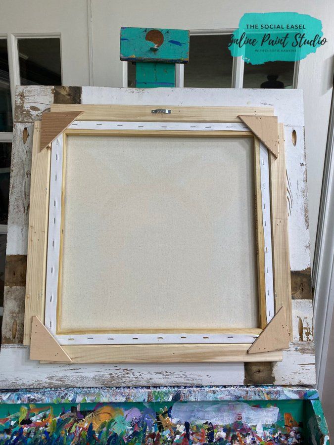 an old wooden frame sitting on top of a table next to other paint and brushes