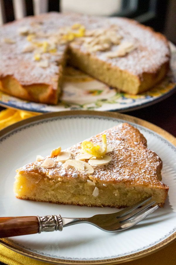 a slice of cake on a plate with a fork next to it and another pie in the background