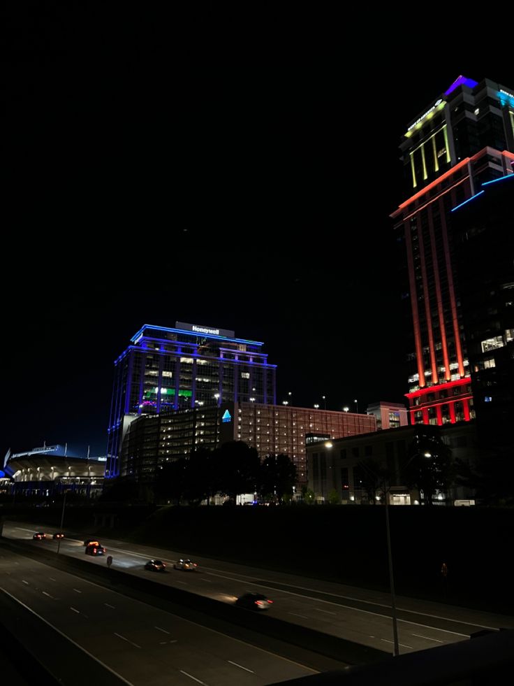 the city is lit up at night with colorful lights on it's skyscrapers