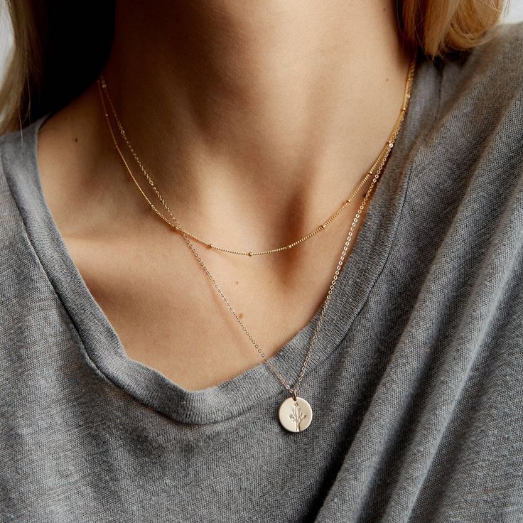 "The perfect set to start your everyday stack. Includes two simple layering necklaces--a dainty satellite chain and a personalized pendant--with your choice of customization (a symbol or initial)!  Every piece is handcrafted and hand-personalized with love in La Conner, WA, using 90% recycled and 100% ethically sourced raw materials from the USA--because it's better that way. Includes free gift-ready packaging (featuring a care card and traditional letterpress goodies made by my dad)!  MATERIALS: * Gold = 14k gold filled * Silver = sterling silver * Rose gold = 14k rose gold filled DETAILS: * Includes 13mm medium disk necklace * Hand-personalized with traditional metal punches * Includes satellite chain with tiny beads AT CHECKOUT: * If you chose \"other\" for length, specify which length Rose Gold Necklaces, Necklace Stacking, Personalized Pendant Necklace, Necklaces Dainty, Gold Beaded Necklace, Layered Necklace Set, Gold Bead Necklace, Sterling Necklaces, Light Rose