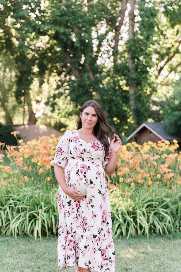 Remain a blooming vision in our Catalina Dress. This lovely dress features a hard-to-miss pink floral print that will remind you to stop and smell the roses. The full-length tiered skirt and half sleeves provide modest coverage for formal occasions. Meanwhile, the stretchy, elastic waistband grants bump-friendly comfort. Pair it with high heels for a look that will make your heart skip a beat. STYLE INFO & CARE Tiered Skirt Fully lined 100% polyester Maternity friendly style Machine Washable in Pink Floral Print Maxi Dress For Maternity, Pink Half-sleeve Maxi Dress For Spring, Pink Half Sleeve Maxi Dress For Spring, Maternity Short Sleeve Maxi Dress For Spring, Feminine Floral Print Maternity Maxi Dress, Feminine Floral Print Maxi Dress For Maternity, Feminine Maternity Maxi Dress With Floral Print, Feminine Short Sleeve Maxi Dress For Garden Party, Pink Flowy Dress With Half Sleeves