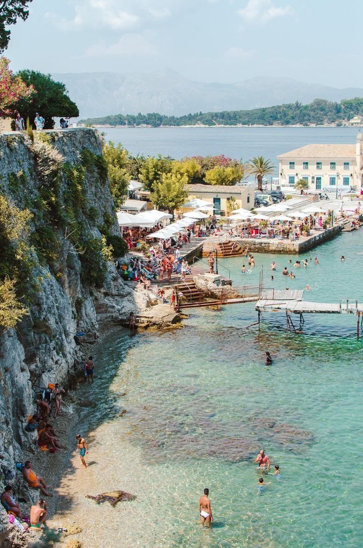 people are swimming in the clear blue water