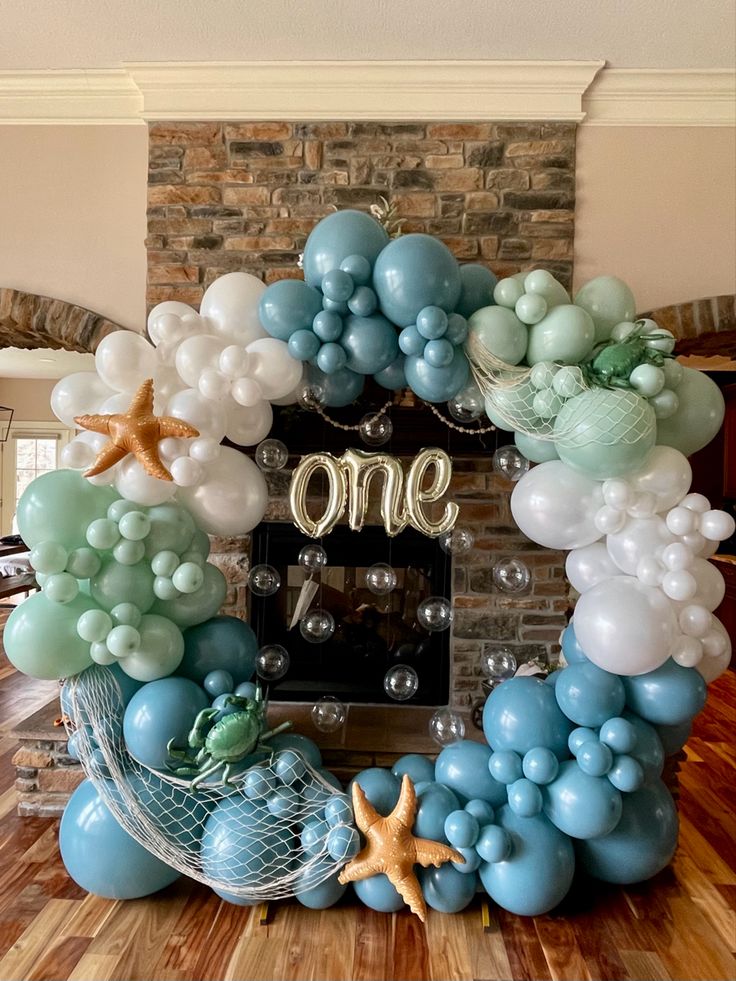 the balloon arch is decorated with blue and white balloons, starfish, and an ocean theme