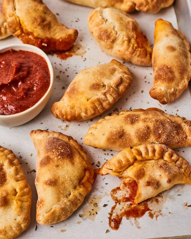 several pastries on a baking sheet with sauce