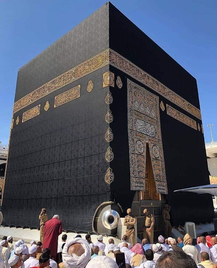 people standing around in front of a large black building with gold and white decorations on it