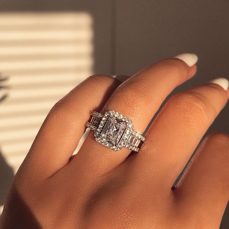 a woman's hand with a diamond ring on it