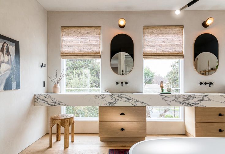 a bathroom with marble counter tops and two round mirrors on the wall above the sink