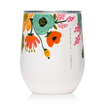 a white cup with colorful flowers painted on the outside and inside, in front of a white background