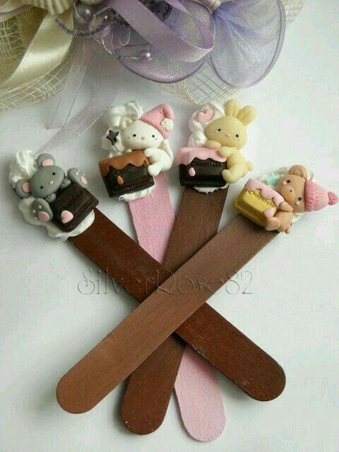 four wooden sticks with small toy animals on them, one is brown and the other is pink