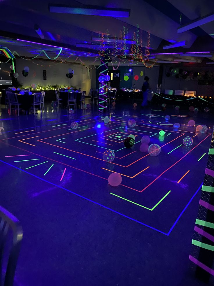 a room filled with neon colored lights and disco balls in the middle of the floor