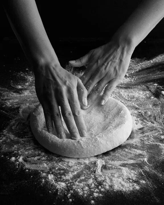 a person kneading dough on top of a table