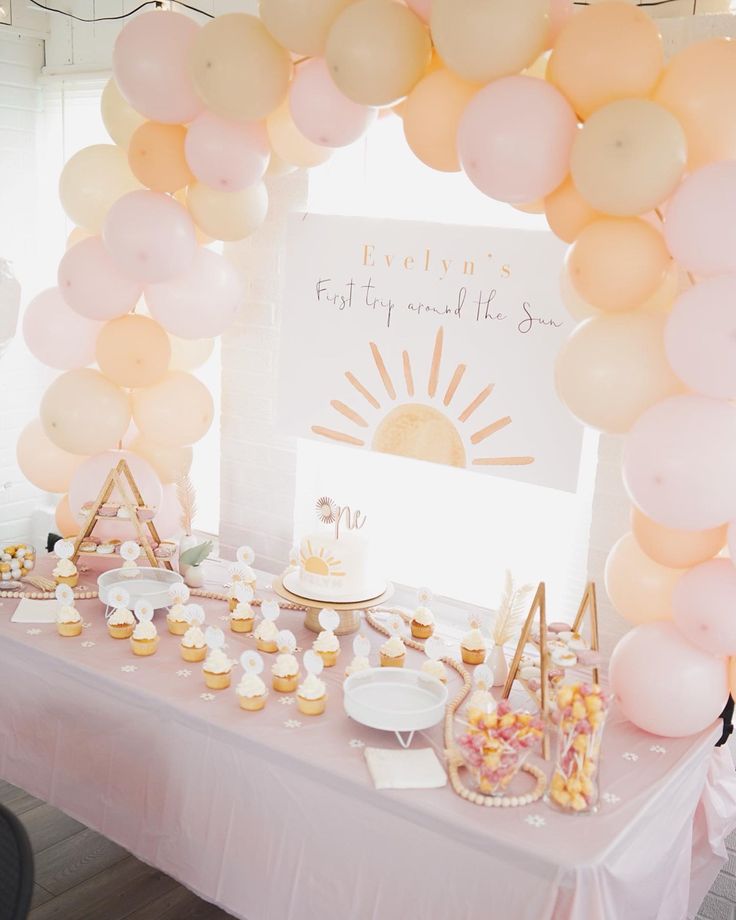 a table topped with lots of balloons and desserts