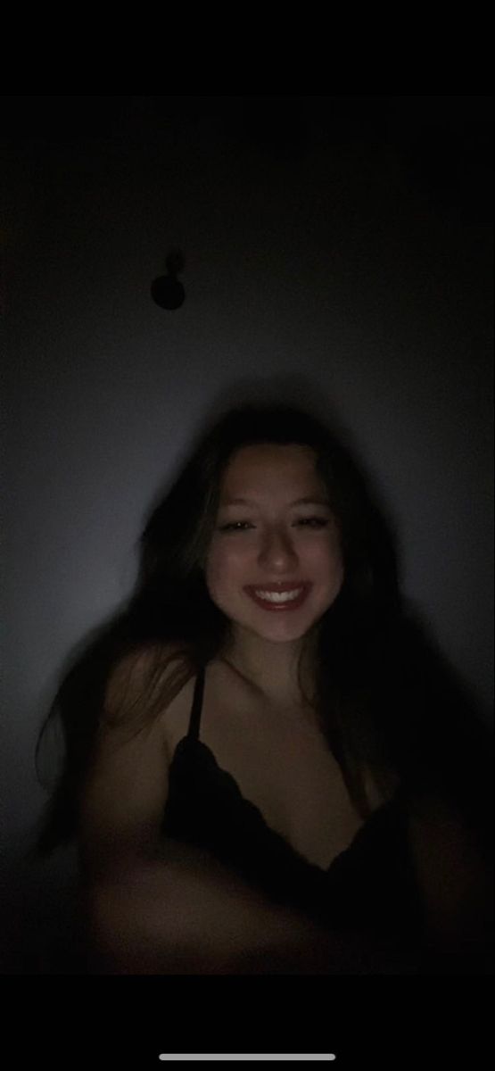 a woman is smiling in the dark