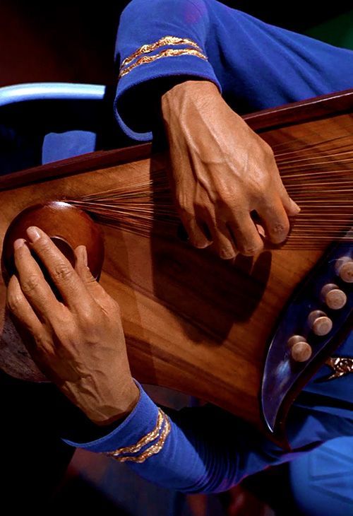 a close up of a person playing an instrument with his hands on the top of it