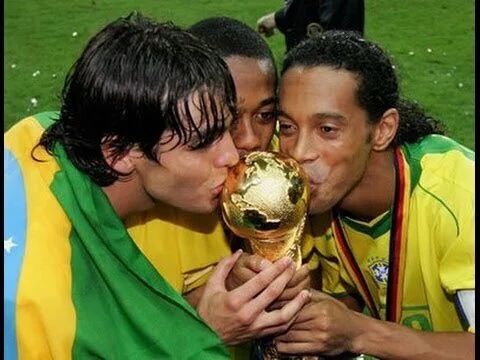 two soccer players kissing each other with the world cup in their hands on a field