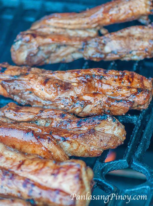 several pieces of meat cooking on a grill