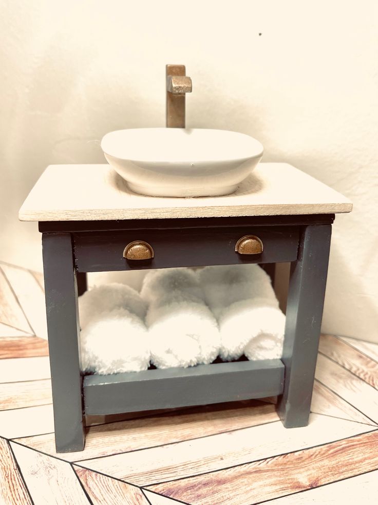 a bathroom with a sink and towels on the shelf in front of it that is made out of wood