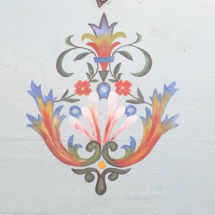 a painting on the side of a building with flowers and leaves painted on it's sides