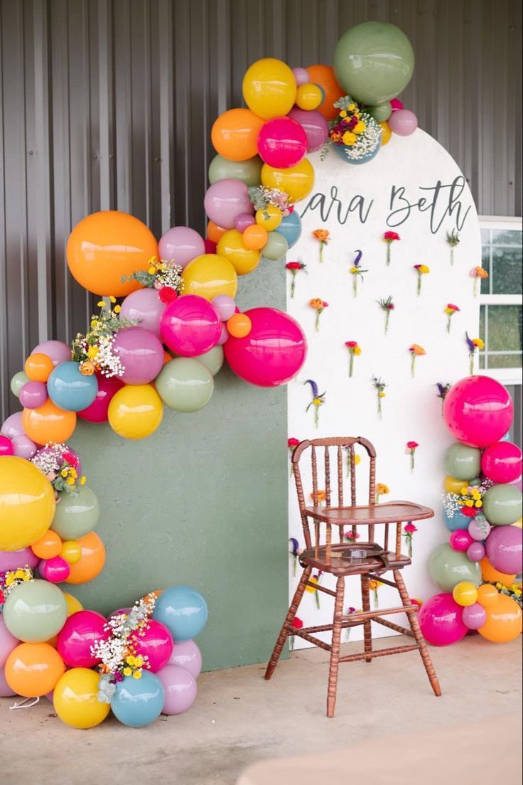 a chair sitting in front of a bunch of balloons