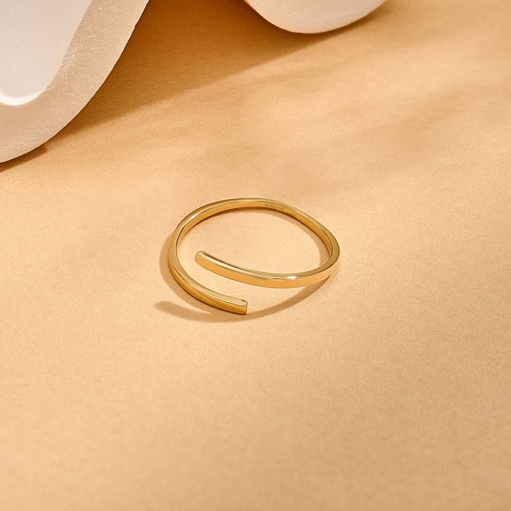 Introducing our Minimalist Bypass Ring, a sleek and understated addition to your jewelry collection. This ring features a plain design that embodies minimalist elegance. Its bypass style allows for effortless stacking with other rings, offering versatility and customization to your look. Elevate your style with this timeless and versatile accessory that exudes simplicity and sophistication. - Made in 14k solid gold - Band Width: 1.42 mm / 0.05 inches - Thickness: 1.06 mm / 0.04 inches -This prod Minimalist Open Stackable Promise Ring, Minimalist Open Midi Rings For Promise, Minimalist Stackable Open Rings For Everyday, Minimalist Adjustable Open Band Ring, Minimalist Open Midi Rings For Everyday, Minimalist Everyday Stackable Open Rings, Everyday Minimalist Stackable Open Rings, Everyday Minimalist Open Midi Rings, Minimalist Adjustable Simple Rings