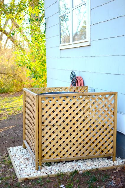 a wooden box sitting on top of gravel next to a building with a fire extinguisher