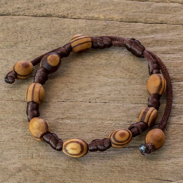 Lesbia Back exalts the beauty found in nature with this handcrafted bracelet. Tropical parota wood beads bring an earthy allure to her design. The Guatemalan artisan knots them by hand and the length can be adjusted by sliding the knot along the dark brown cords. Adjustable Natural Jewelry With Wooden Beads, Adjustable Natural Wooden Bead Jewelry, Adjustable Natural Wooden Beaded Jewelry, Natural Wooden Beads Spiritual Bracelet, Adjustable Nature-inspired Jewelry With Wooden Beads, Adjustable Nature-inspired Wooden Beads Jewelry, Earthy Wooden Beads Adjustable Bracelet, Earthy Adjustable Bracelet With Wooden Beads, Artisan Wooden Beads Bracelets For Meditation