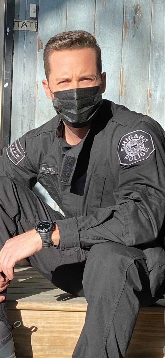 a man wearing a face mask sitting on a bench