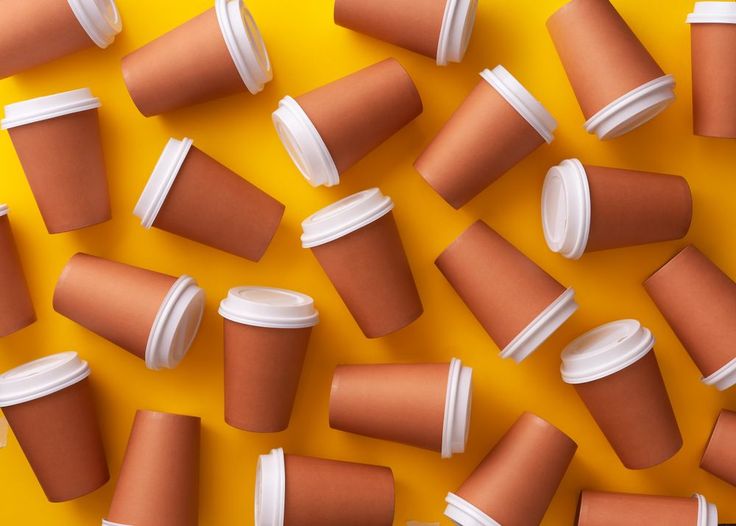 coffee cups are arranged in the shape of a pattern on a yellow background with white caps