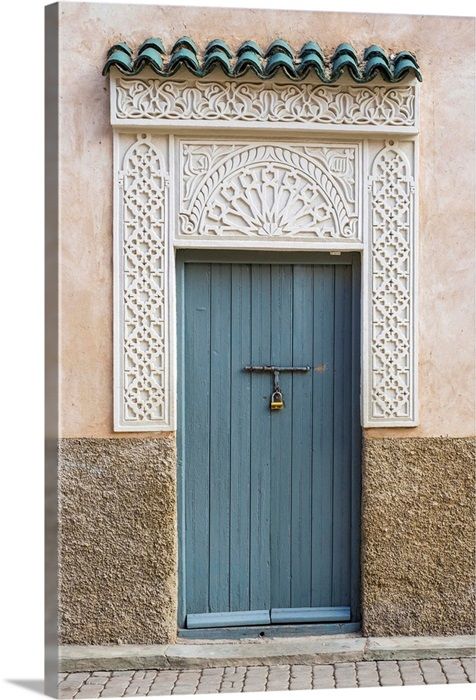 a blue door on the side of a building with an ornate design and green roof