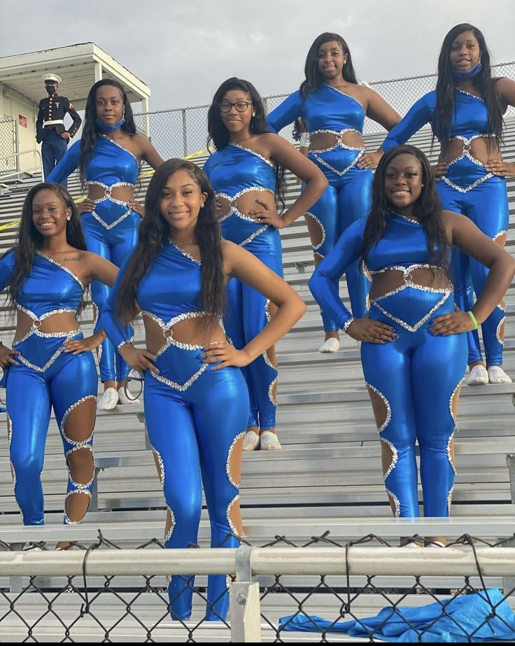 a group of women in blue outfits standing on bleachers