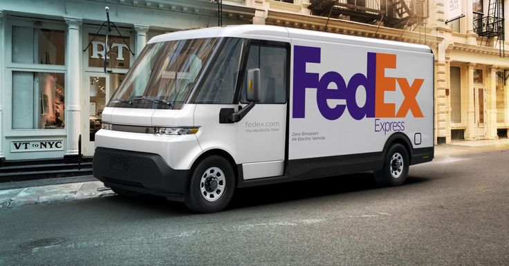 a fed ex delivery truck parked on the side of the road in front of a building