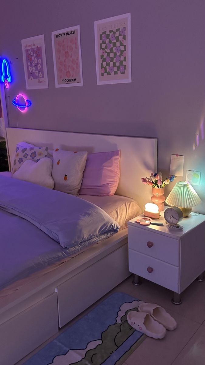 a white bed sitting in a bedroom next to a night stand with two lamps on it