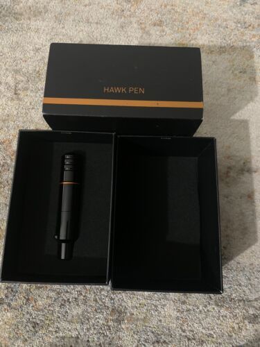 an open box with a black pen in it sitting on top of a carpeted floor