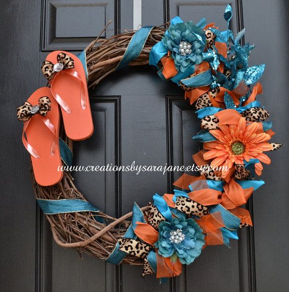 a wreath with flip flops, flowers and leopard print sandals on the front door