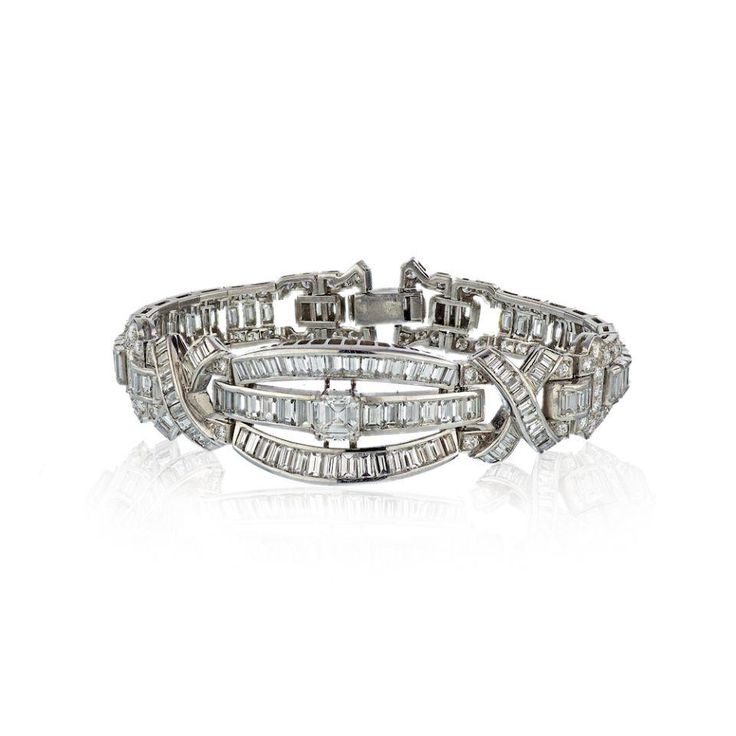 Circa 1960's Platinum Diamond Bracelet with a 1 carat center Emerald Cut and approximately 20 carats of small round and baguette diamonds.Center Diamond Weight: 21.00Metal Type: PlatinumMetal Weight: 47.1 gr.Stock: RR4736 Platinum Diamond Bracelet With Brilliant And Baguette Cut, Luxury Platinum Diamond Bracelet With Emerald Cut, Platinum Diamond Bracelet With Vvs Clarity In Baguette Cut, Luxury Palladium Hardware Bracelets For Formal Occasions, Classic Luxury Jewelry With Palladium Hardware, Luxury Estate Jewelry For Anniversary, Luxury Platinum Emerald Cut Diamond Bracelet, Luxury Estate Silver Jewelry, Luxury Silver Bracelet With Palladium Hardware