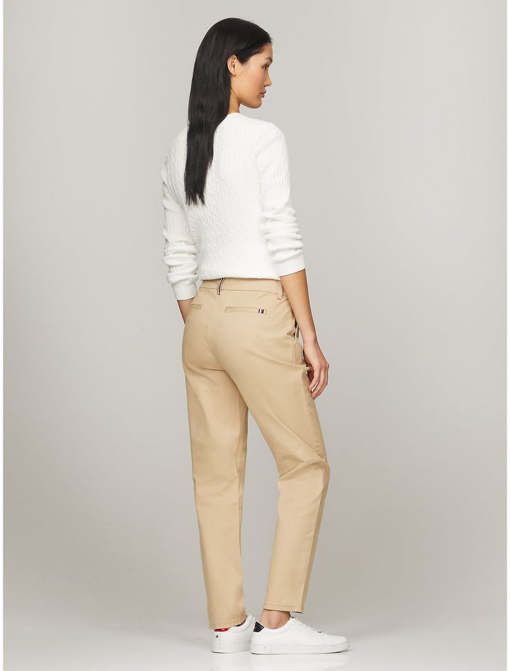 Tommy Hilfiger women's pant. Cut in a slim fit, our chino is made from a stretch-cotton blend offering lightweight breathability and comfort.  Material: 98% Better Cotton Initiative, 2% Elastane. Classic Slim Fit Mid-rise Chinos, Slim Fit Mid-rise Classic Chinos, Slim Fit Mid-rise Chinos For Work, Mid-rise Cotton Chinos For Work, Classic Mid-rise Chinos For Business Casual, Classic Mid-rise Cotton Chinos, Classic Tommy Hilfiger Tapered Leg Bottoms, Beige Straight Bottoms, Tommy Hilfiger Classic Tapered Leg Pants