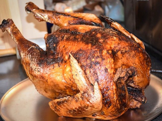 a roasted turkey on a plate in front of an oven