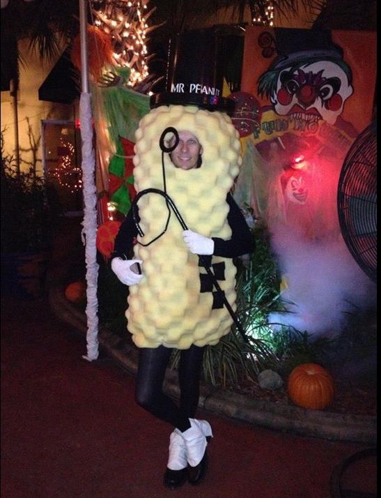 a man dressed in a costume standing next to a palm tree with lights on it