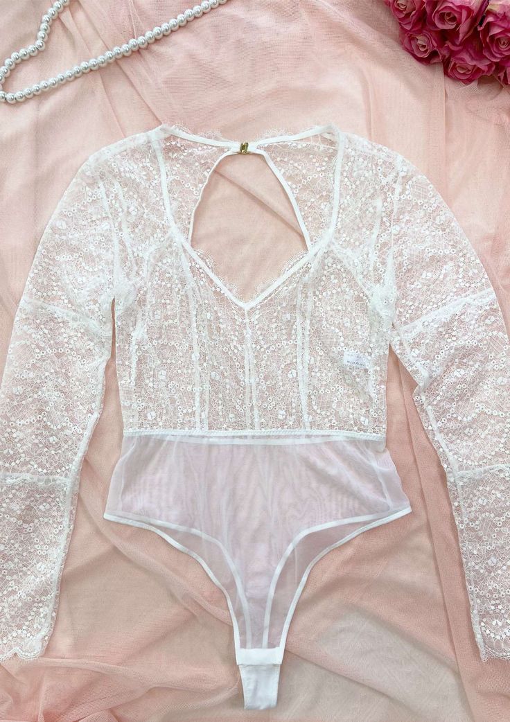 Feel absolutely fabulous in our stunning Teddy bodysuit! This exquisite piece is crafted with delicate lace, delivering a gorgeous and feminine aesthetic that celebrates your inner beauty. Designed with full-coverage long sleeves, this bodysuit allows you to confidently embrace your unique style and wear it wherever your heart desires. Long sleeve Semi-sheer Full lace Thong bottom and cotton lining V-neck Fitted Bodysuit With Lace Closure For Night Out, Lace Stretch Bodysuit For Night Out, Stretch Lace Bodysuit For Night Out, Fitted Long Sleeve Lace Bodysuit, Stretch Lace Long Sleeve Bodysuit, Lace Bodysuit For Party, Elegant Long Sleeve Lace Bodysuit, Long Sleeve Lace Bodysuit For Party, Party Lace Bodysuit With Lace Trim