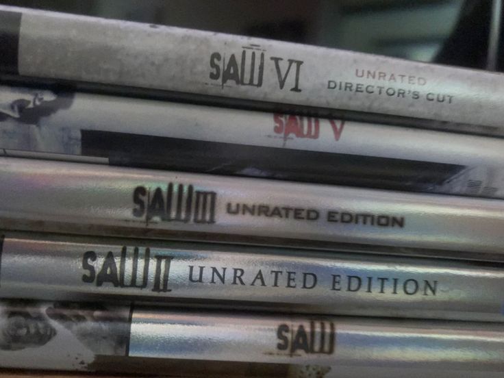 a stack of dvds sitting on top of a wooden table