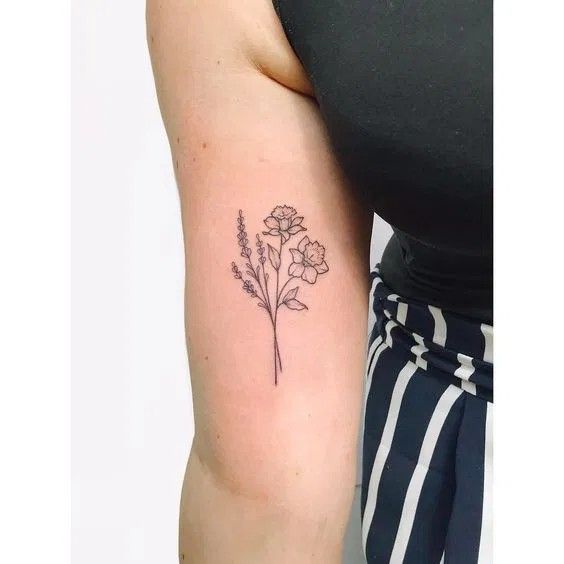 a woman's arm with a flower tattoo on the left side of her arm